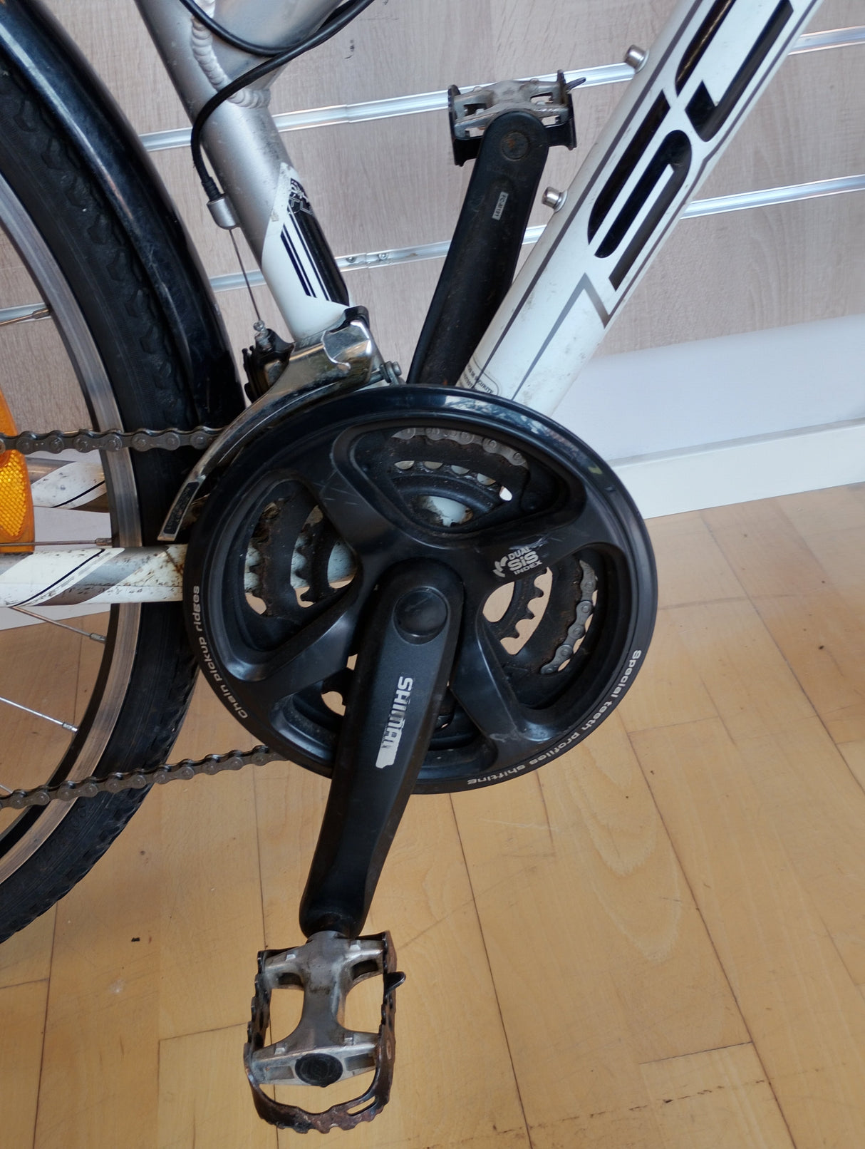 Shimano vevparti och pedal på vit cykel, närbild av cykeldrivlina
