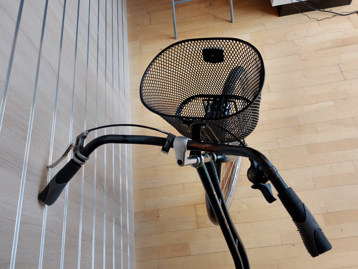 Cykelstyre med korg och svarta handtag, fokus på cykeltillbehör