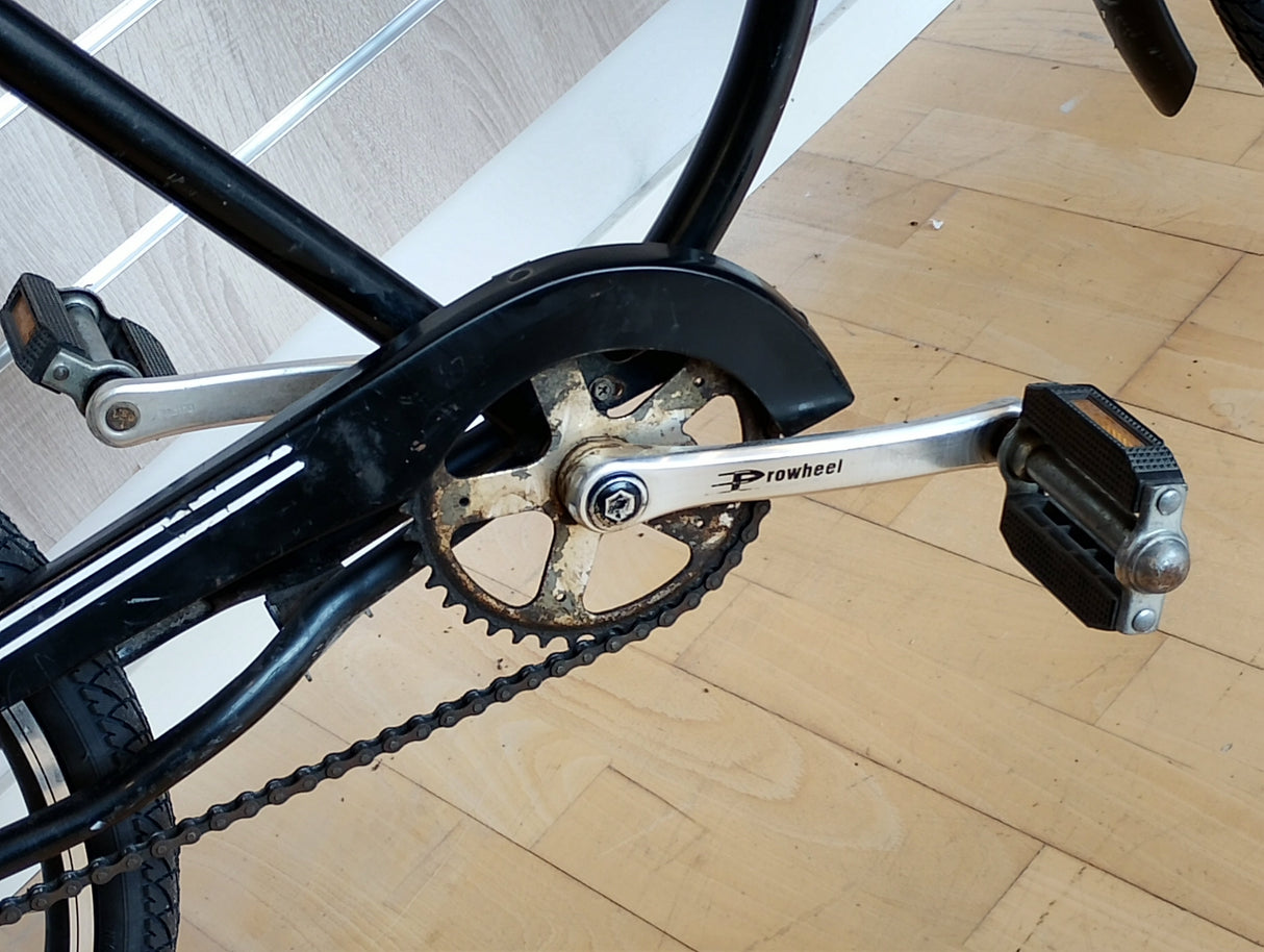 Cykeltrampor och vevparti med Prowheel vevarm, närbild på cykelkedja och drev.