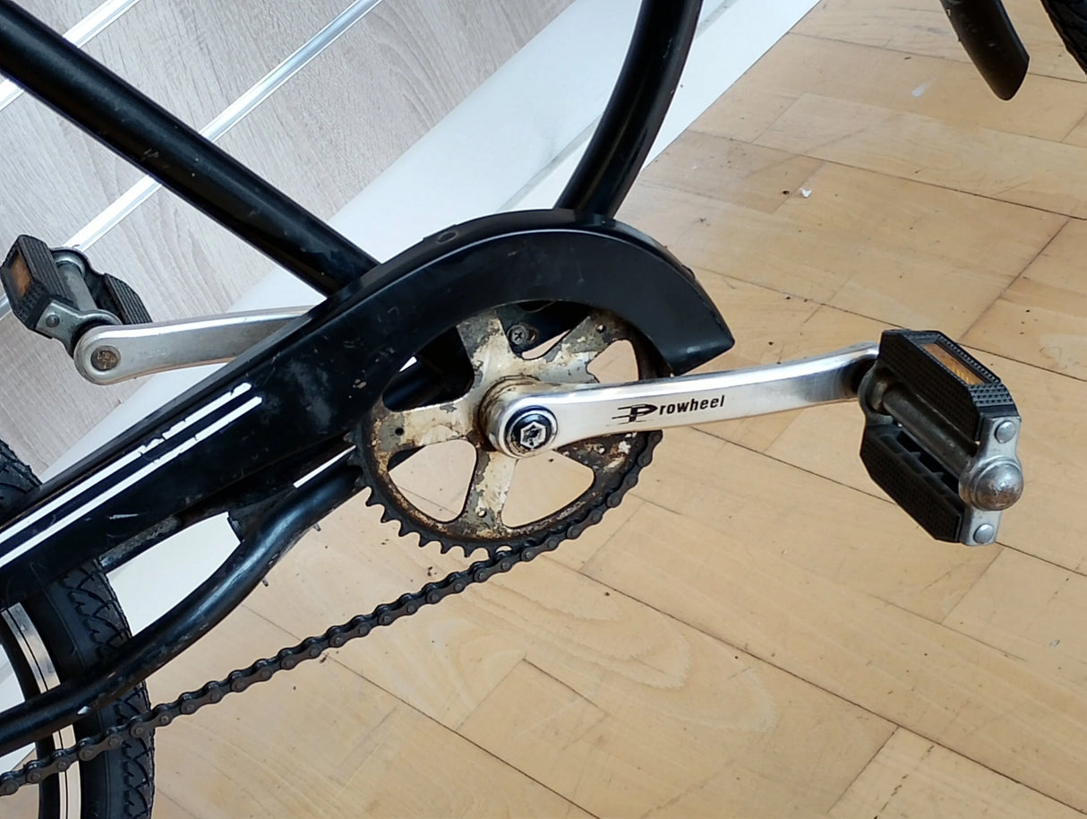 Cykeltrampor och vevparti med Prowheel vevarm, närbild på cykelkedja och drev.