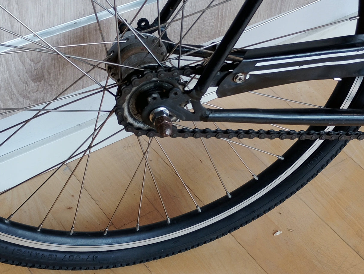 Cykelhjul bakhjul med kedja och ekrar på svart cykel, närbild