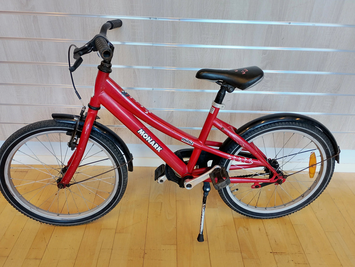 Röd Monark miniz barncykel med svarta stänkskärmar och reflex på bakhjulet