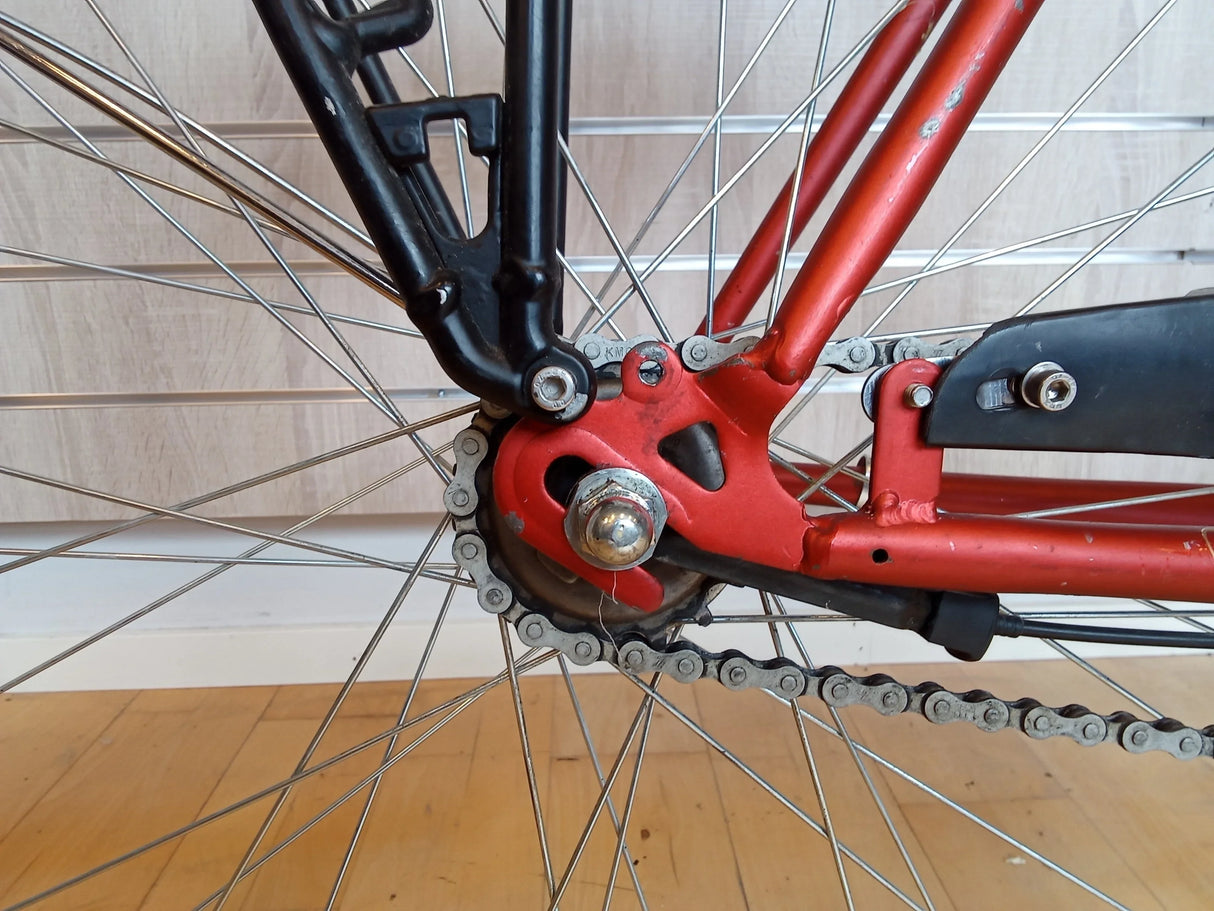 röda cykelram och kedjespännare med bakhjul och kedja på cykel