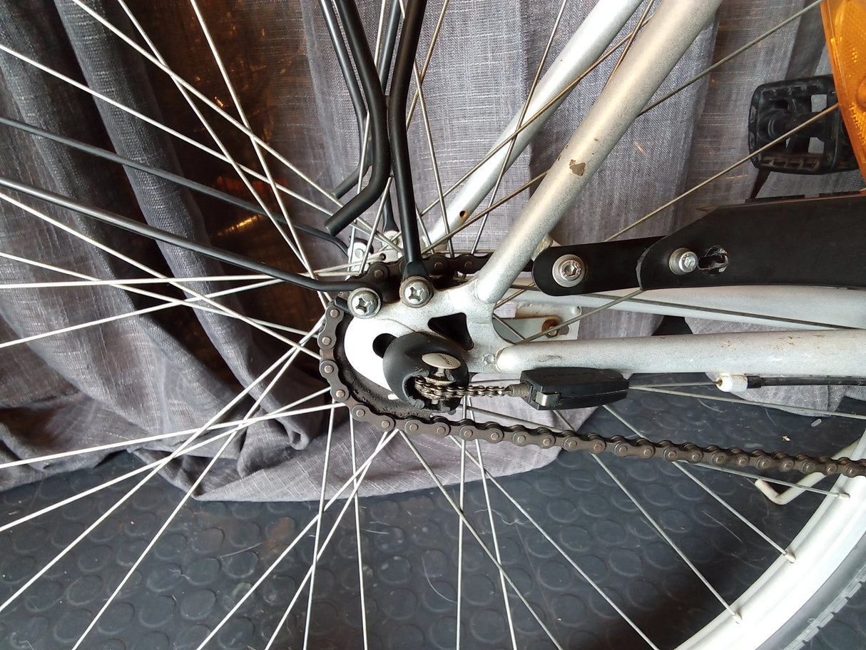 Bakre kedjedrev och kedja på silverfärgad cykel med svarta detaljer och reflex