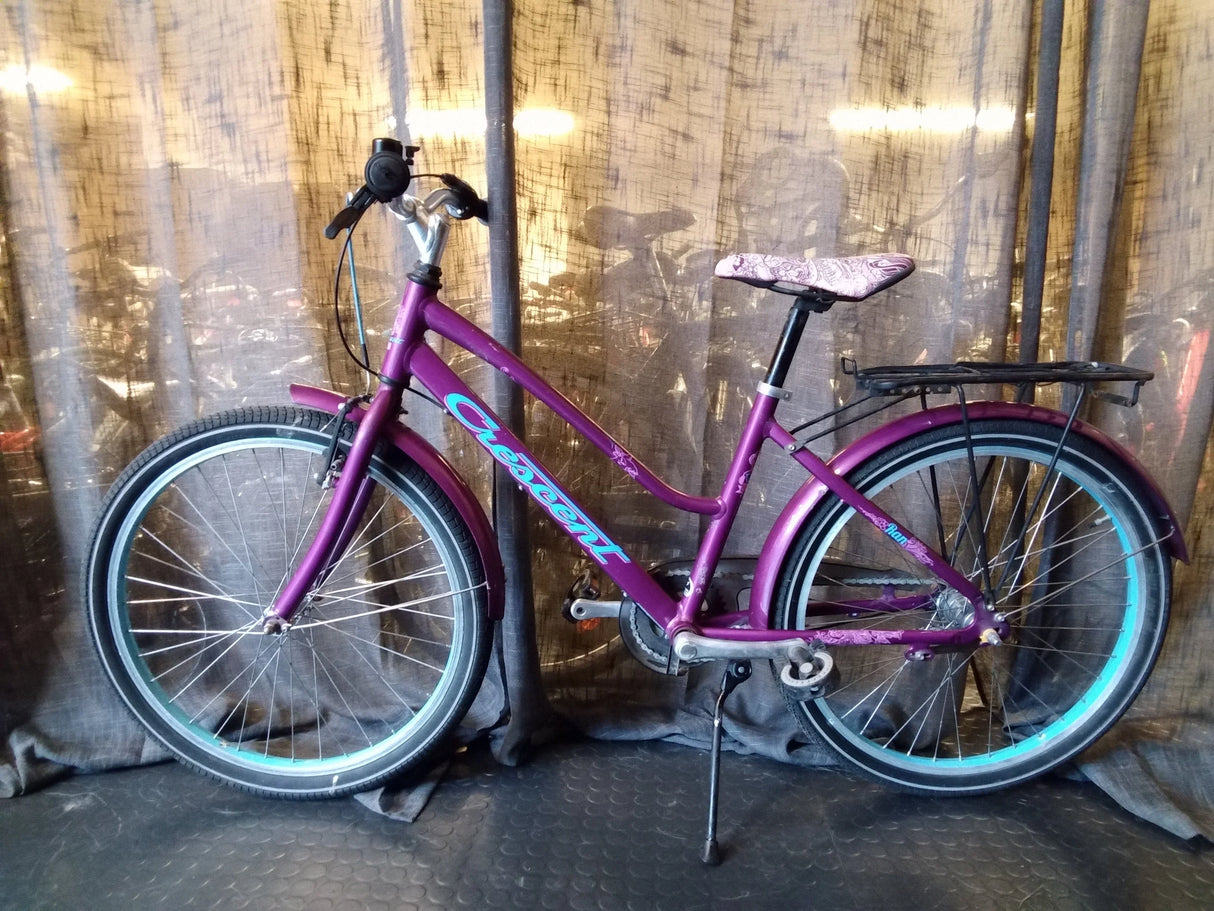 Lila Crescent damcykel med blåa detaljer, pakethållare och mönstrad sadel