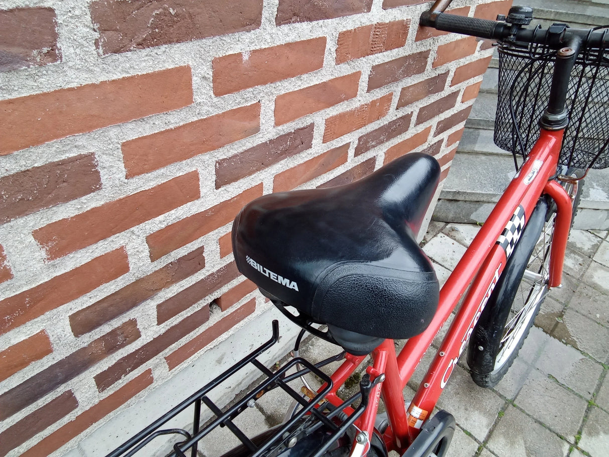Röd cykel med svart Biltema-sadel och korg fram