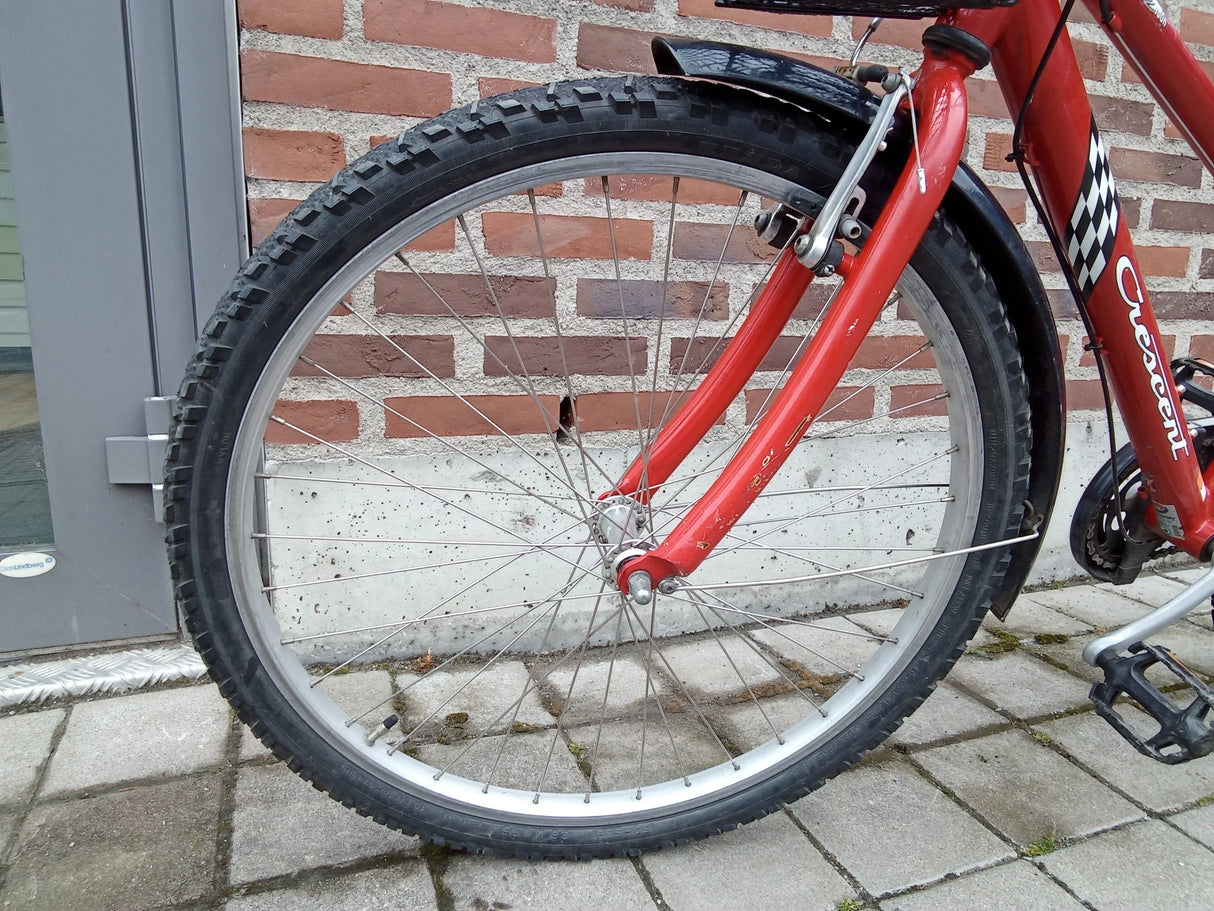 Rött Crescent cykelhjul med grovmönstrad däck och svart skärm