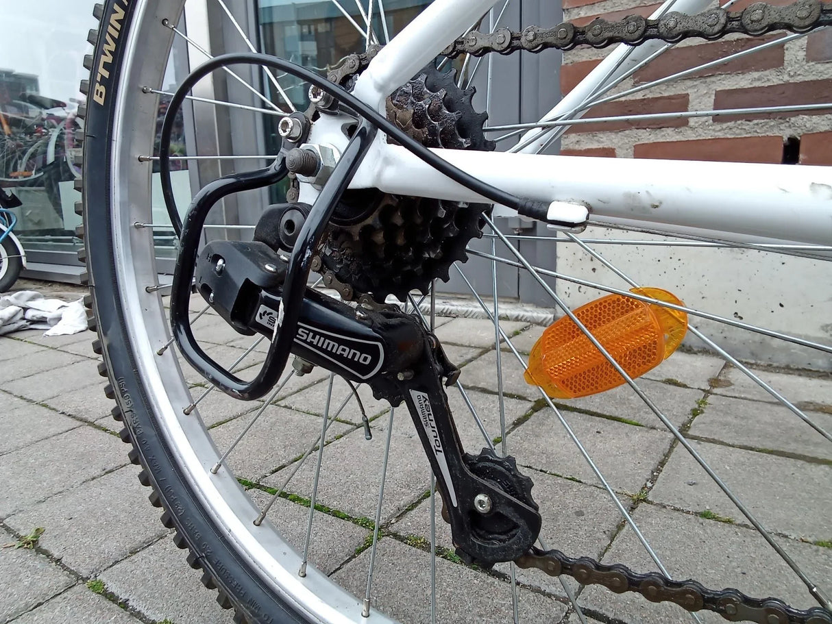 Cykelhjul med Shimano Tourney växeldel och orange reflex på vit ram