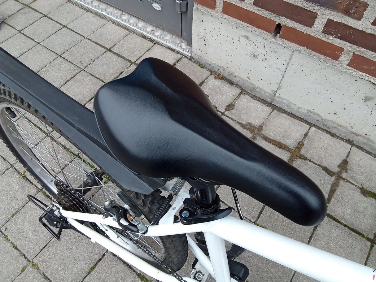 Svart cykelsadel på vit mountainbike med skivbroms och bakhjul