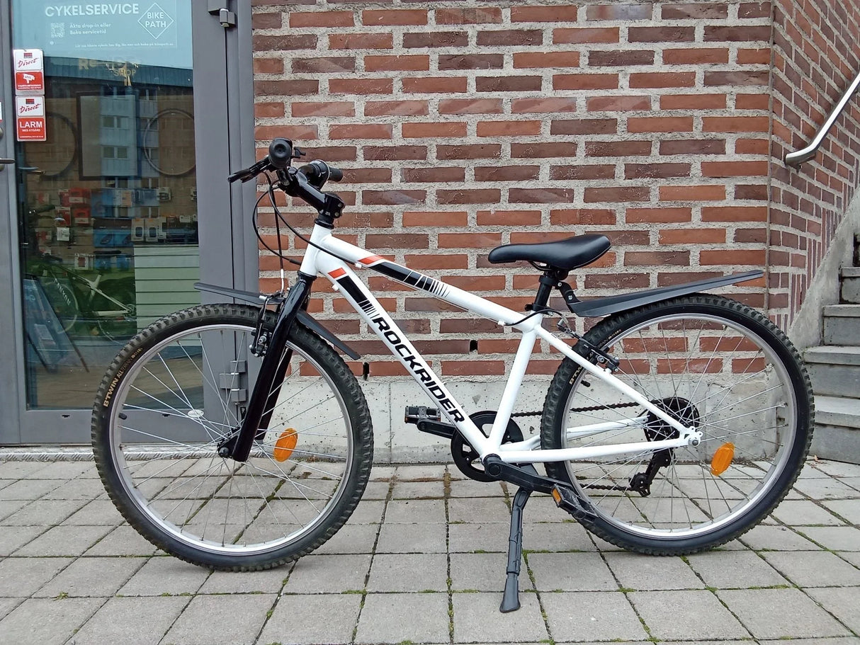 Vit mountainbike Rockrider med svart sadel, skärmar och däck med dubbar
