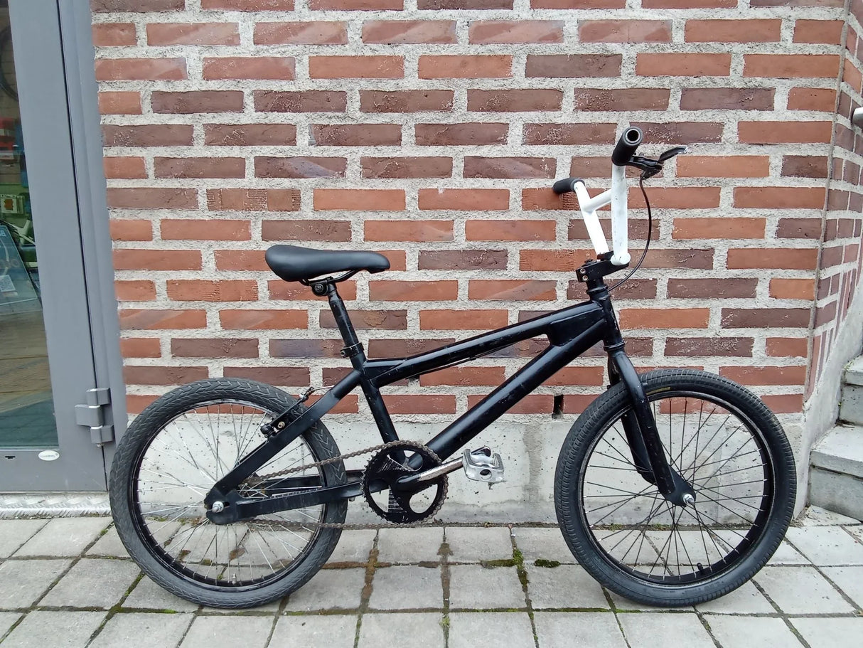Svart BMX-cykel med vita styret grepp och svart sadel