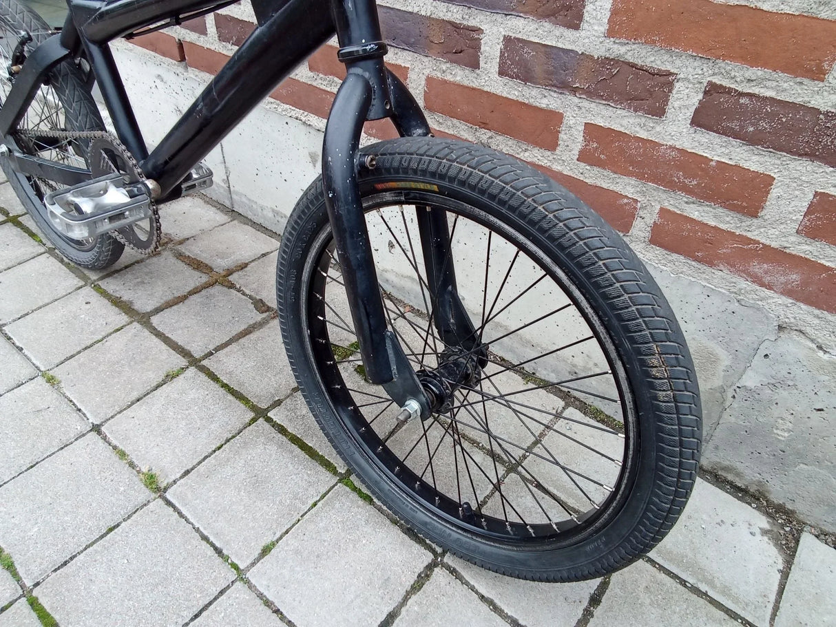 Svart BMX-cykel med tydligt framhjul och grovmönstrat däck