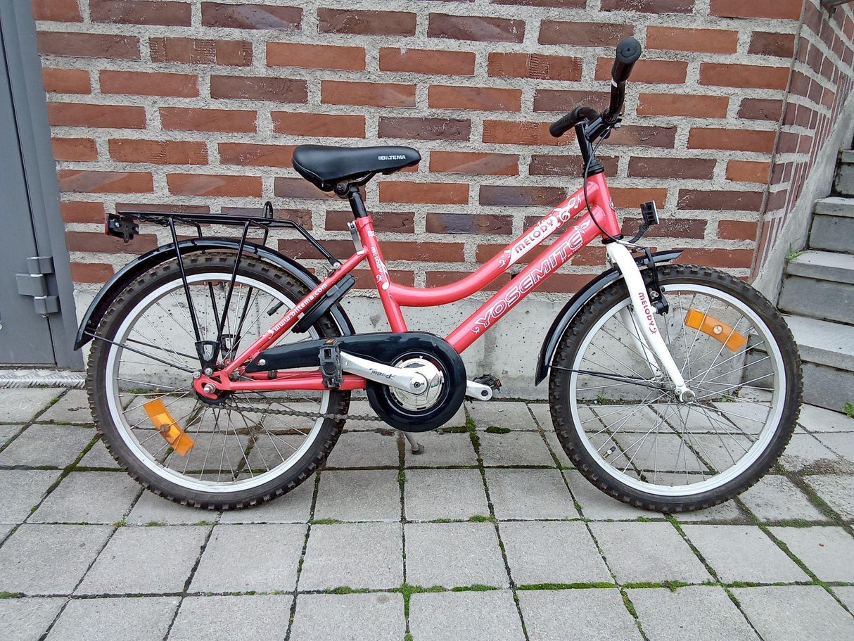 Röd barncykel Yosemite med svart sadel, vit framgaffel och stapel hoppare på hjulen