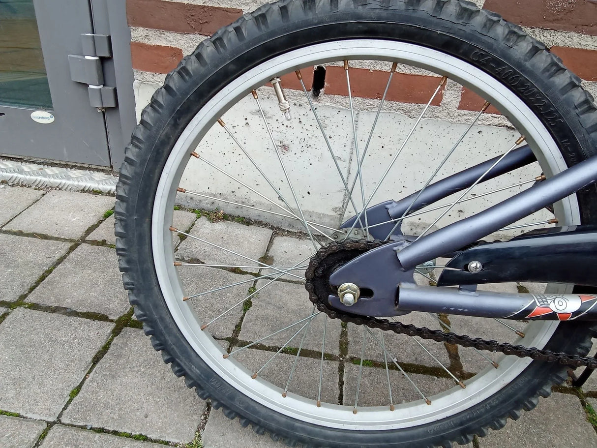 Närmast bakhjulet på en cykel med tjockt slitbanedäck och kedja vid navet