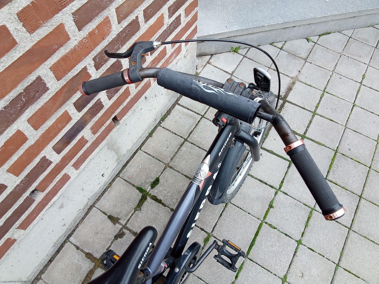 Svart mountainbike med mjuka handtag, bromshandtag och klädd styrstång
