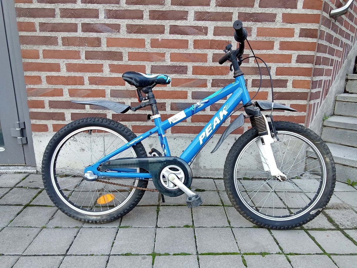 Blå barncykel med svart sadel, skärmar och terrängdäck