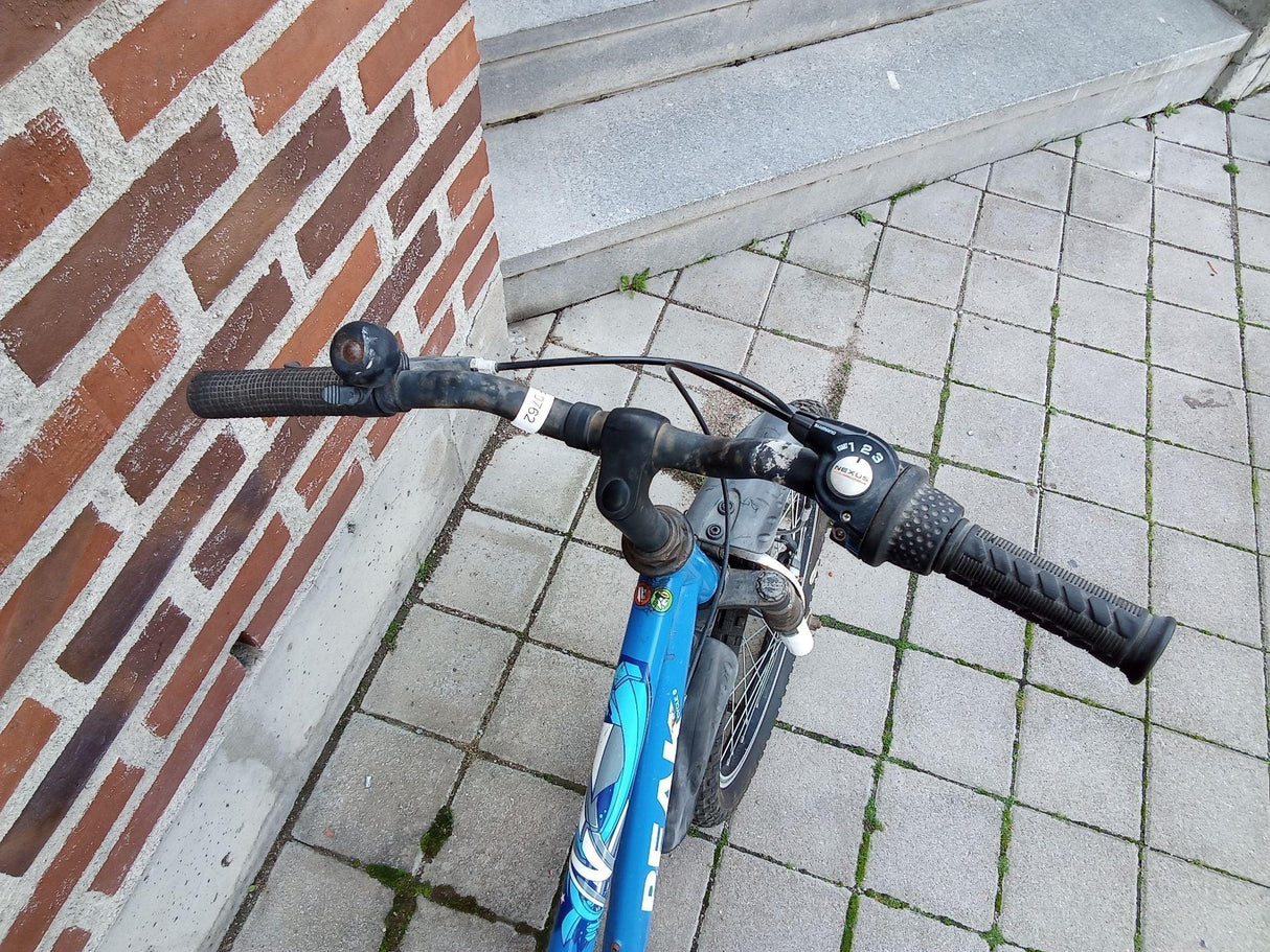 Blå barncykel med svart styre, Shimano Nexus växlar och ringklocka på trottoar