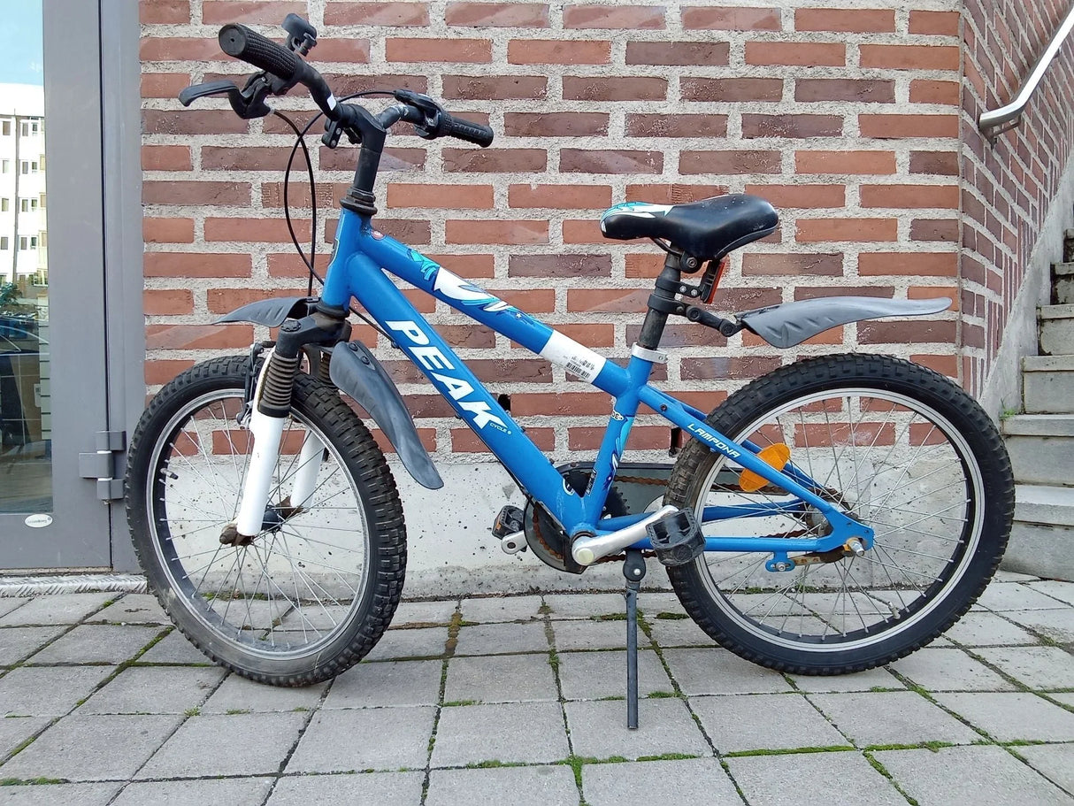 Blå PEAK cykel med punkteringsrika däck och svart säte