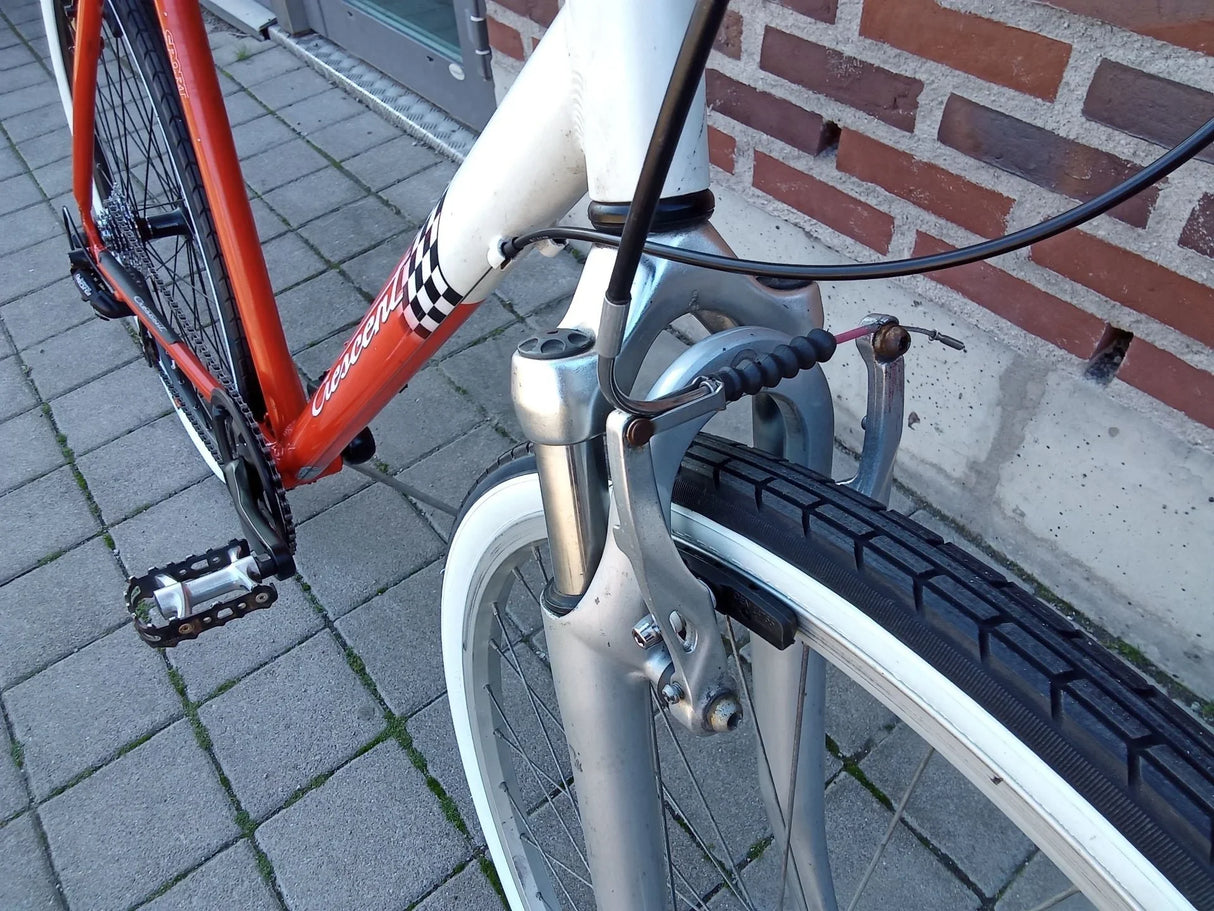 Närbild på framhjul och bromsarm på Crescent sportcykel med orange och vit ram