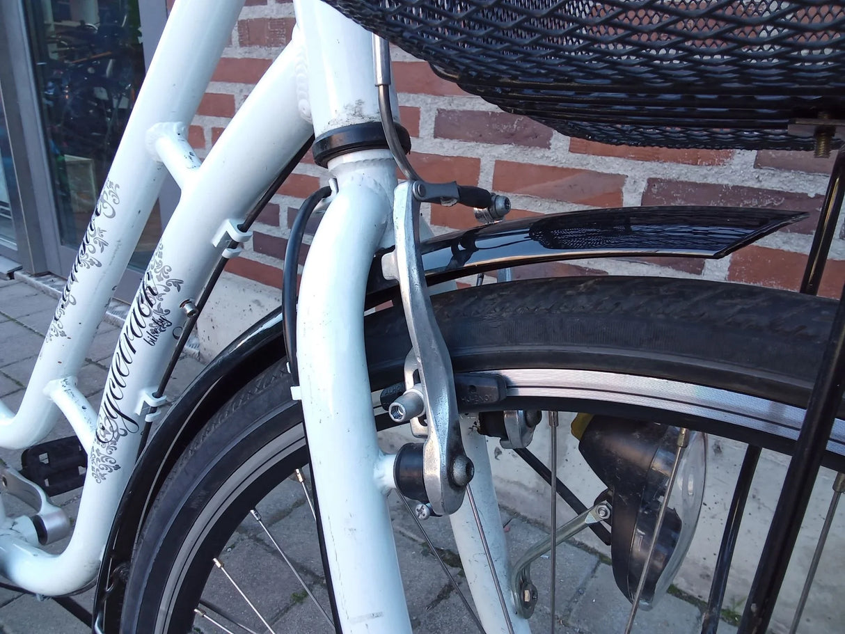 Vit cykelram med svart skärmskydd, broms och cykeldäck detaljer