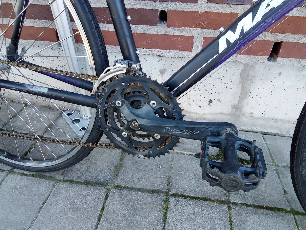 Cykelpedal och kedja på svart mountainbike med Shimano växelsystem
