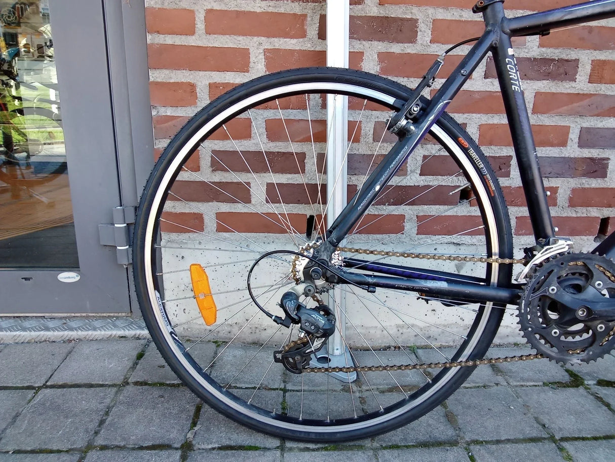 Cykelns bakhjul med Shimano Altus växelsystem och orange reflex på däcket