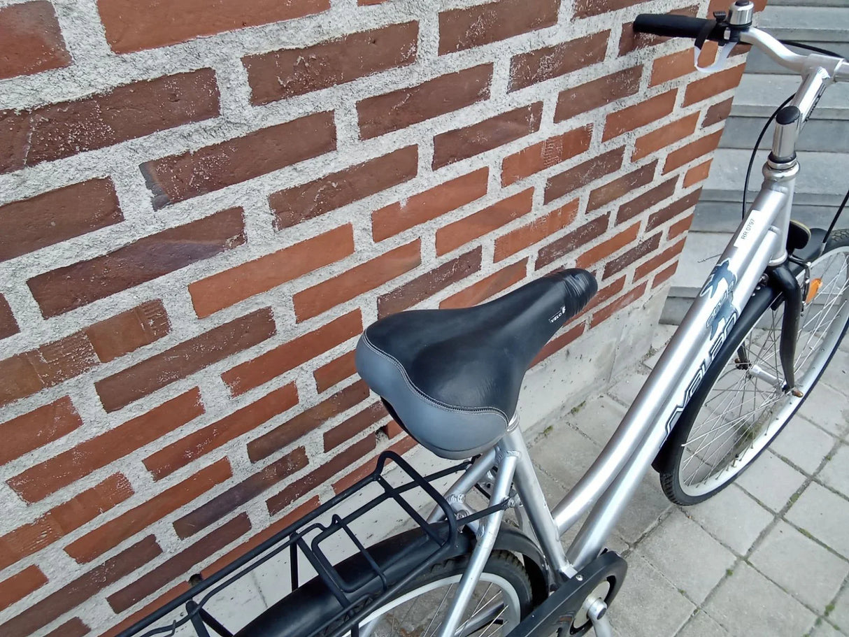 Silver cykel med svart sadel, pakethållare och styre