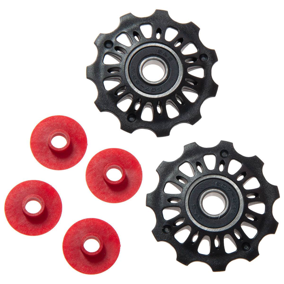 Svarta cykelväxelhjul med fyra röda spacer-skivor, cykeldelar