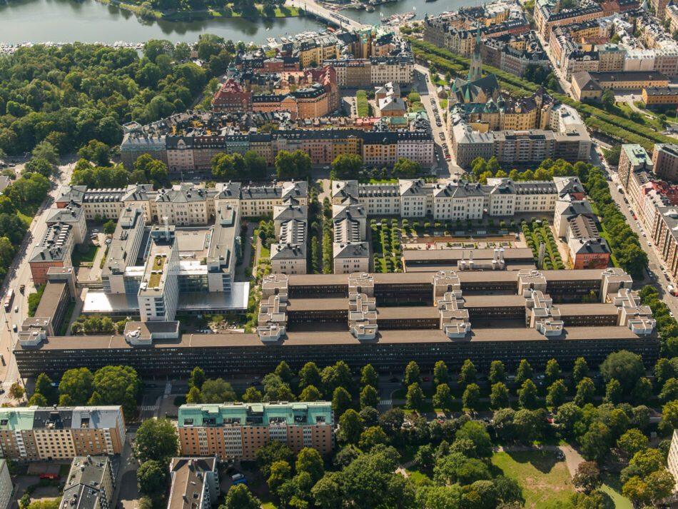 Luftbild över Stockholms stad med byggnader, träd och vatten, idealisk för cykling och stadsutflykter.