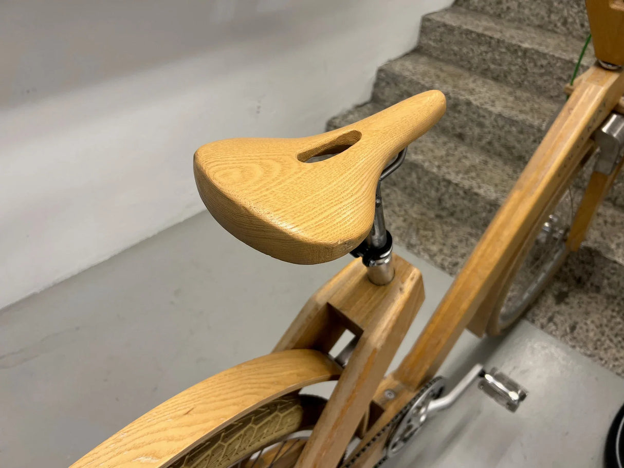 Cykelsadel och ram i trä med pedaler och kedja synliga