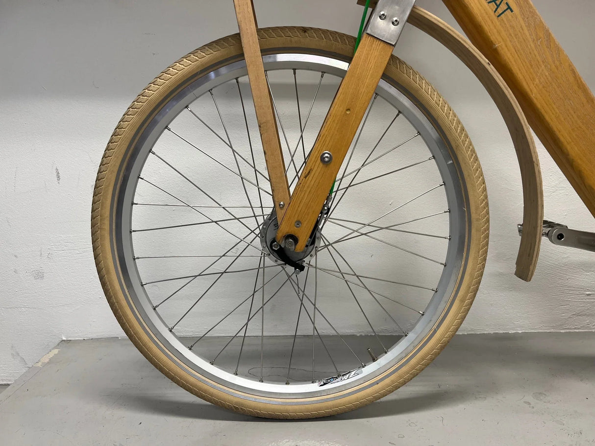 Frambroms och hjul med beige däck och träram på cykel