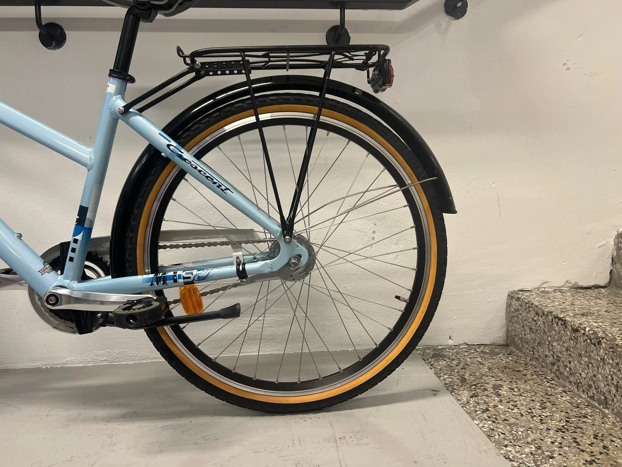 Ljusblå Crescent cykel med svart pakethållare och beige kant på bakdäcket