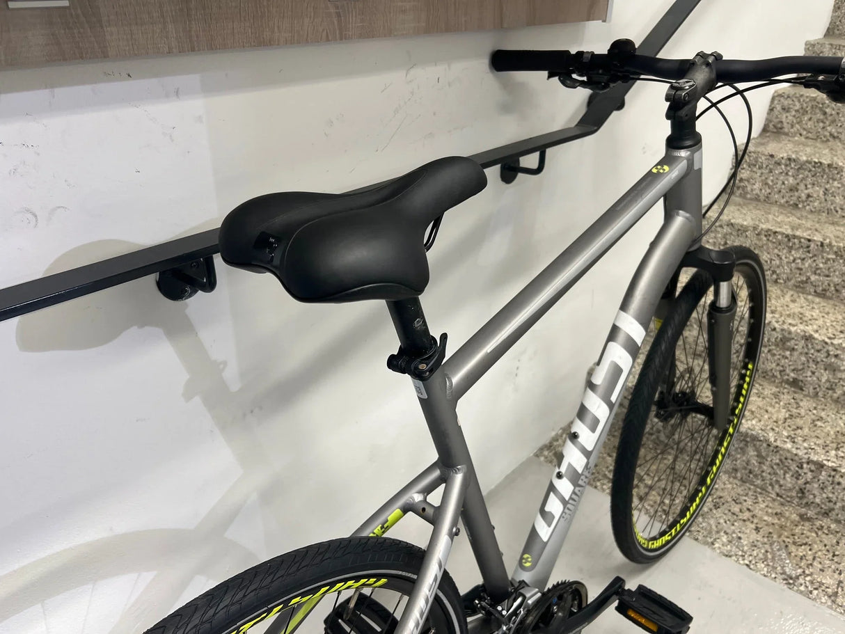 Grå svart cykel med svart sadel och gula kantstreck på däcken nära trappa