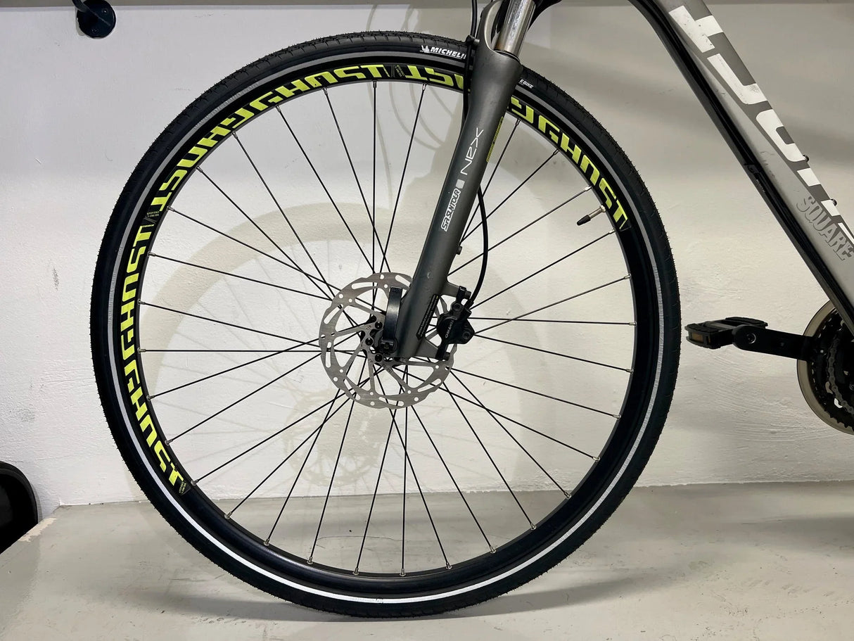 Framhjul på grå cykel med skivbroms och däck med texten Schwghost i gult