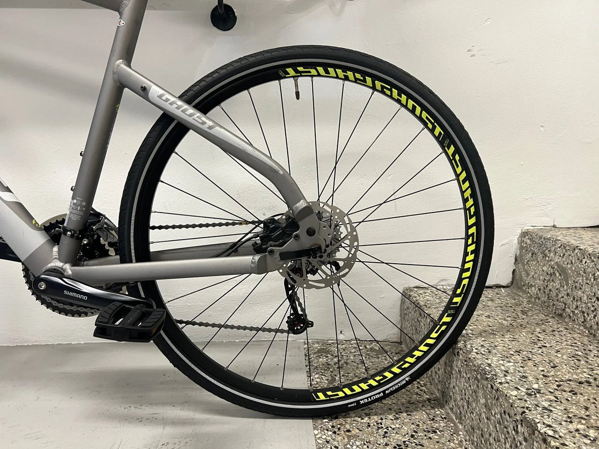 Grå Ghost cykel bakhjul med Shimano växlar och skivbroms, svarta hjul med gula märkningar