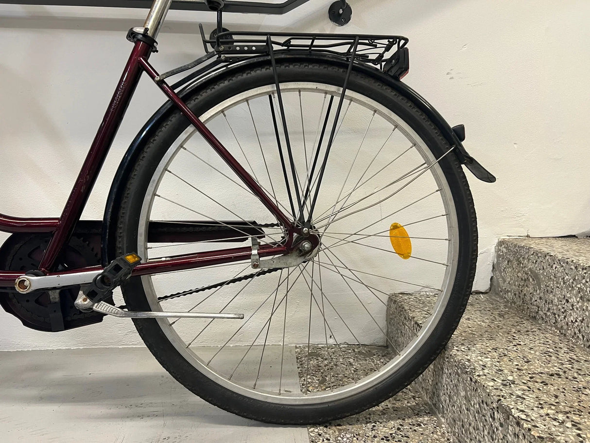 Bakre hjul på cykel med svart däck, silverfälg och orange reflektor