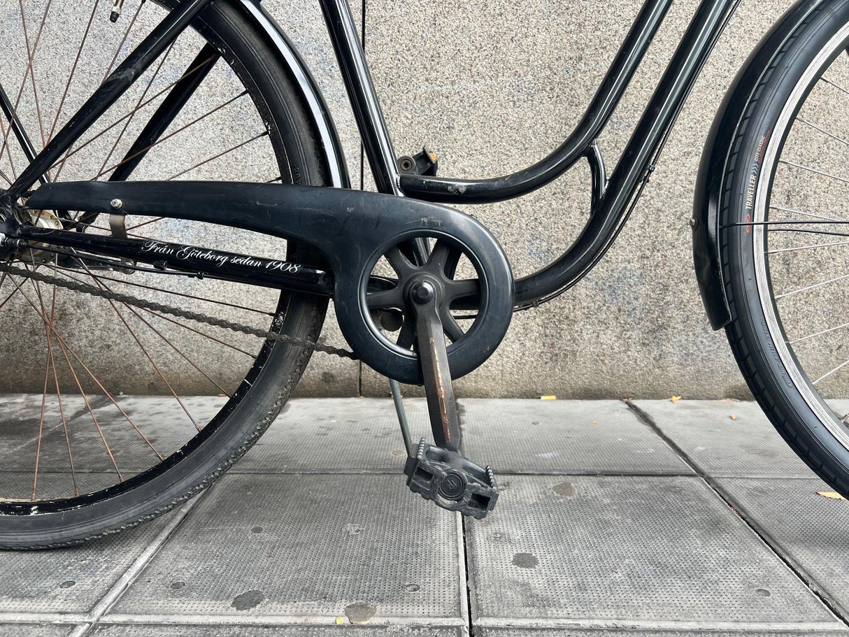 Svart cykelkedjeskydd och trampor med text från Göteborg sedan 1908 på cykelramen