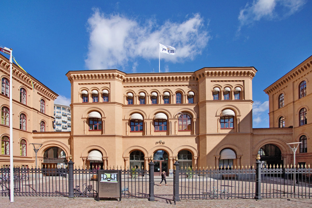 Historisk byggnad med flagga och cyklar framför, idealiskt för cykelverkstad i Stockholm