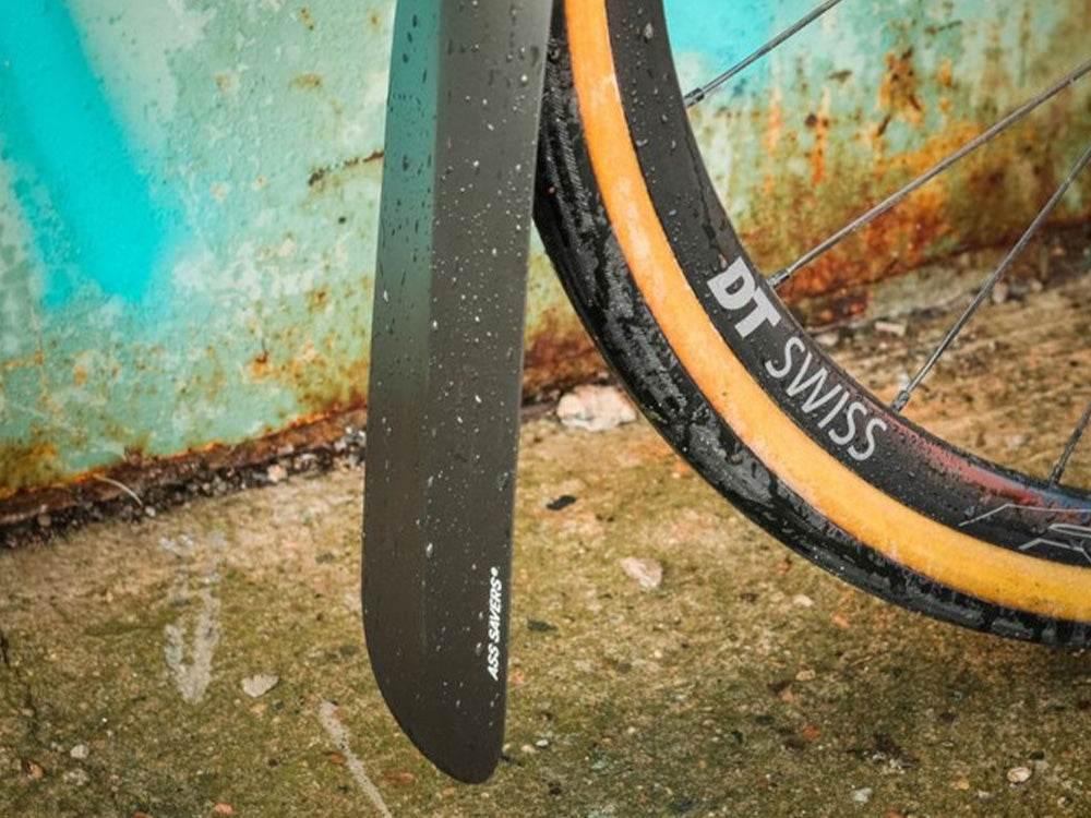 Svart ASS SAVERS cykelskyddsförlängare monterad på DT Swiss cykelhjul med beige däck