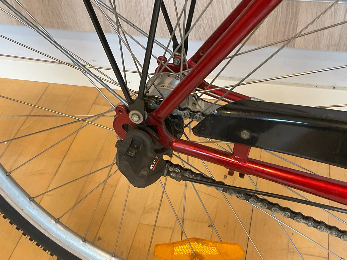 Bakre cykelhjul med röd ram, pedaldrev och svart Shimano Nexus växelsystem