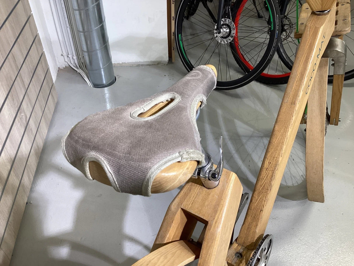 Träsadelskydd i grått och cykel med trästel ram och rostfri kedja