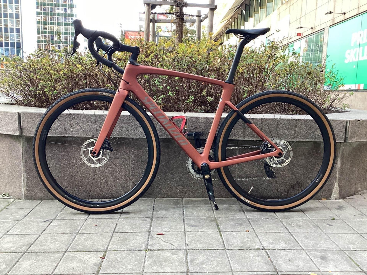 Specialized racercykel i matt terrakotta med svarta däck och läderfärgade kantväggar