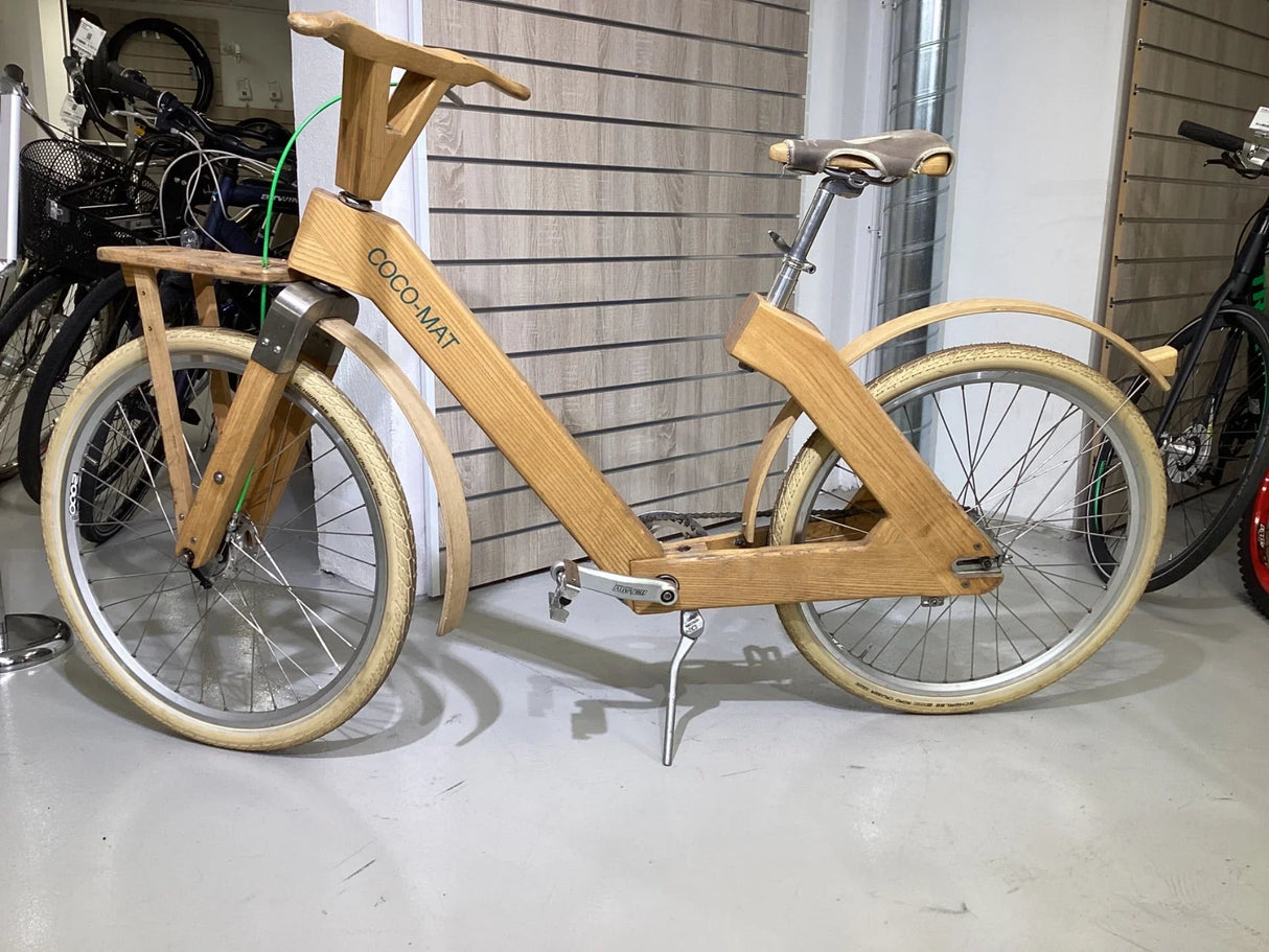 Träcykel med breda vita däck och märket COCO-MAT på ramen