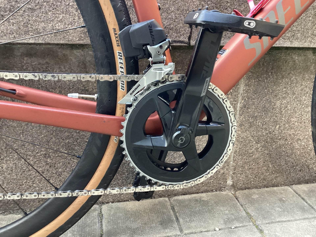 Närbild på cykelns kedja, vevparti och Maxxis Rekon Race däck med SRAM-komponenter