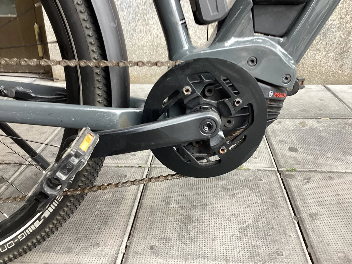 Närbild på elcykels vevparti och kedja med Bosch-motor och pedal