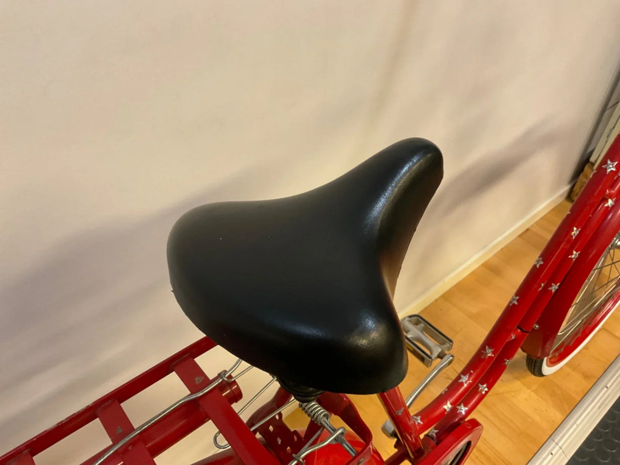 Svart cykelsadel på röd infälld ramcykel med stjärnmönster