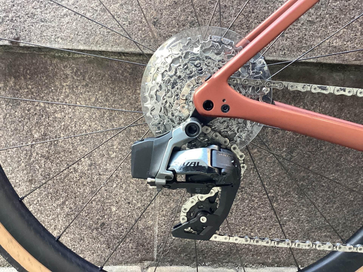 Bakväxel och kedja på cykel med rosa ram och bred kassett