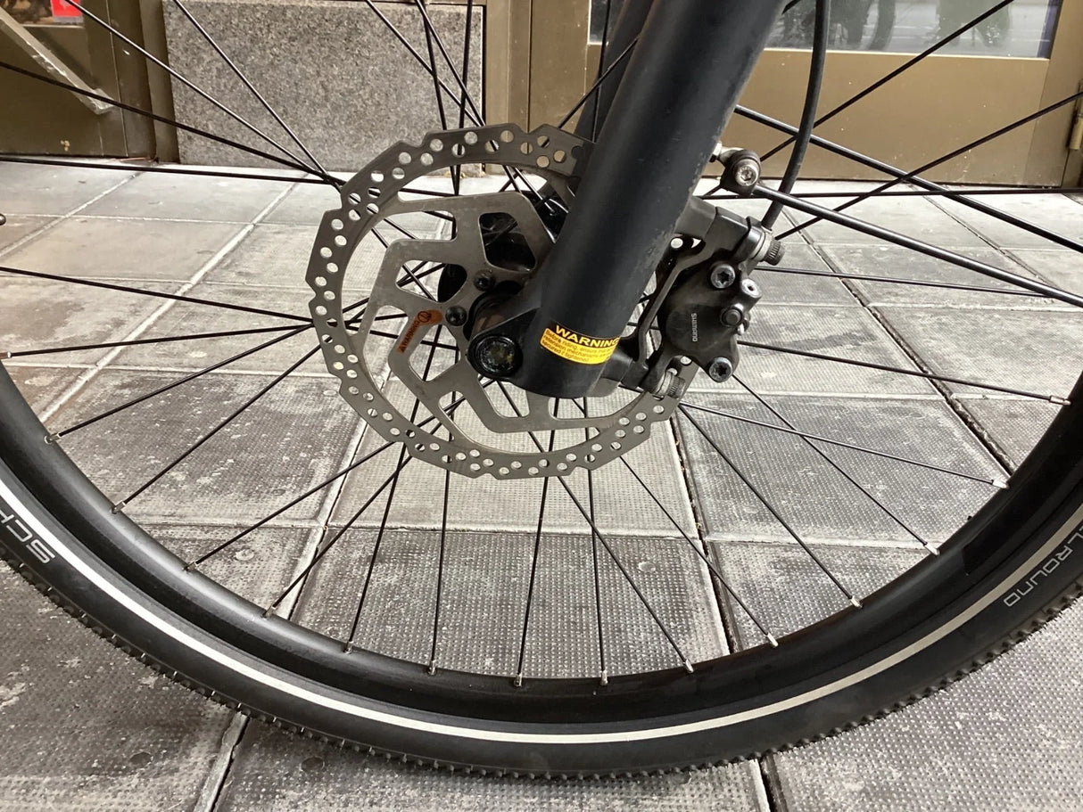 Cykelhjul med svart däck, skivbroms och Shimano bromsok