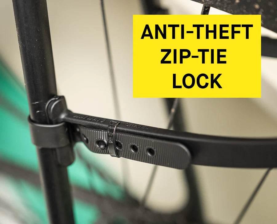 Antistöld cykellås zip-tie monterad runt svart cykelram och hjul, närbild