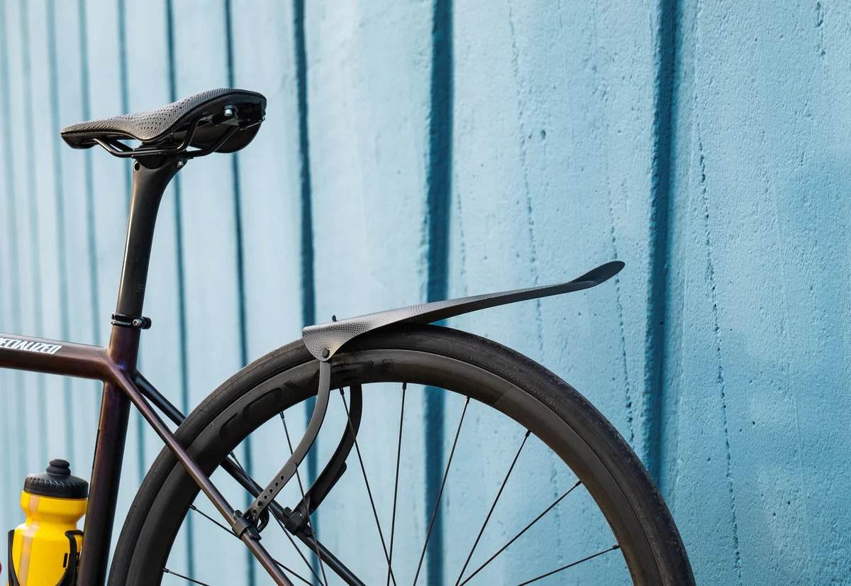 Cykel bakskärm monterad på racercykel med svart sadel och gul vattenflaska